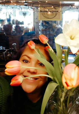 Eva lächelt hinter Tulpen hervor
